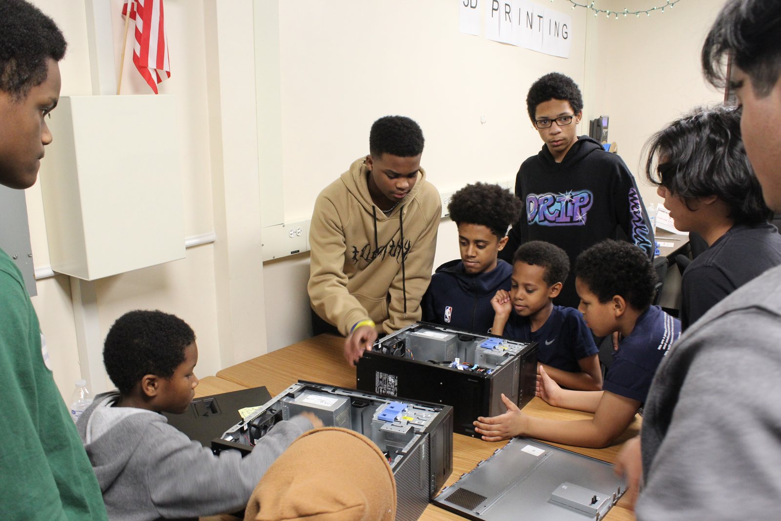 Students teaching around open computer towers